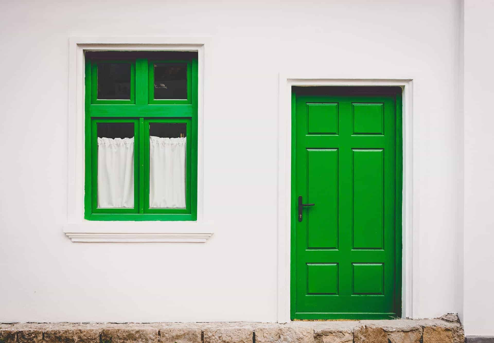 Green door and window on white house